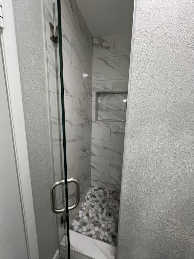 bathroom featuring a shower with shower door