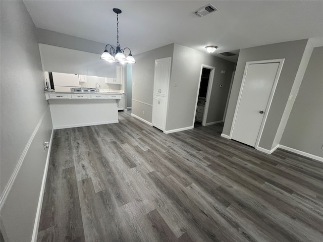 unfurnished dining area with a notable chandelier and dark hardwood / wood-style floors