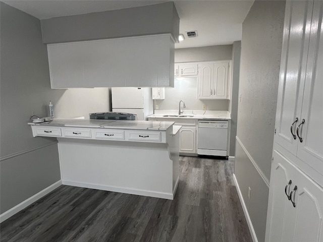 kitchen featuring white appliances, sink, kitchen peninsula, white cabinets, and dark wood-type flooring