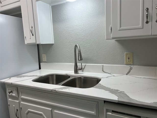 kitchen with white cabinetry, light stone countertops, sink, and dishwasher