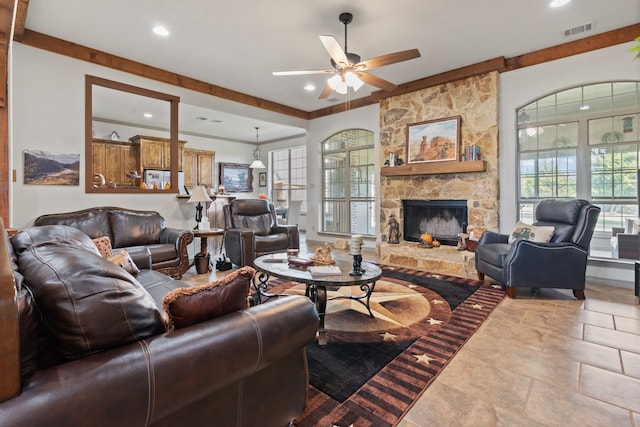 living room featuring a stone fireplace and ceiling fan