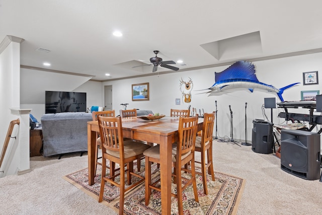 carpeted dining space featuring ornamental molding and ceiling fan