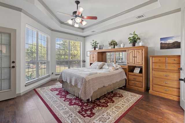 bedroom with ceiling fan, a raised ceiling, ornamental molding, and dark hardwood / wood-style flooring