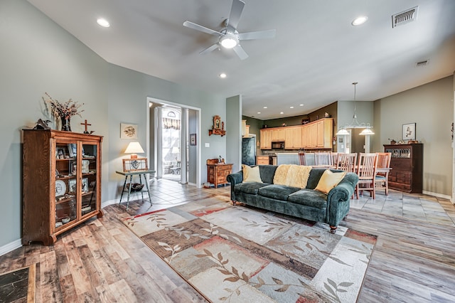 living room featuring ceiling fan and light hardwood / wood-style floors