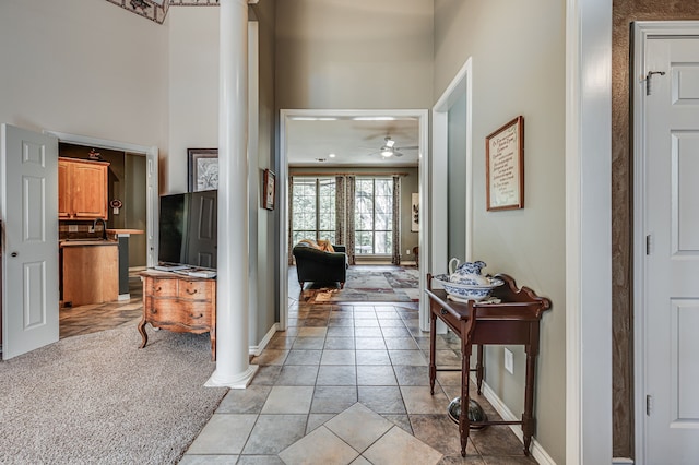 hallway featuring light colored carpet and ornate columns