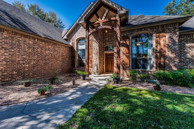 view of exterior entry featuring a yard