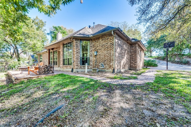 back of house featuring a lawn, a patio, and an outdoor fire pit