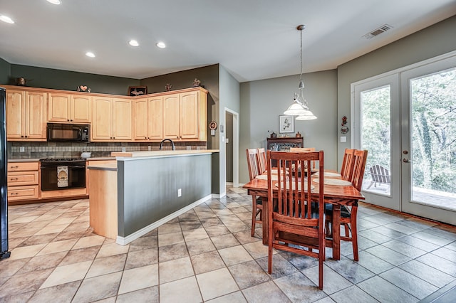 kitchen featuring hanging light fixtures, black appliances, light brown cabinetry, decorative backsplash, and french doors