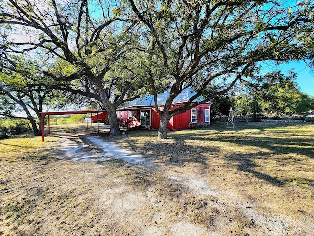 view of front of property featuring an outdoor structure and a front yard