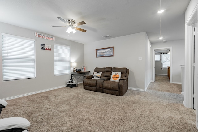 carpeted living room with ceiling fan