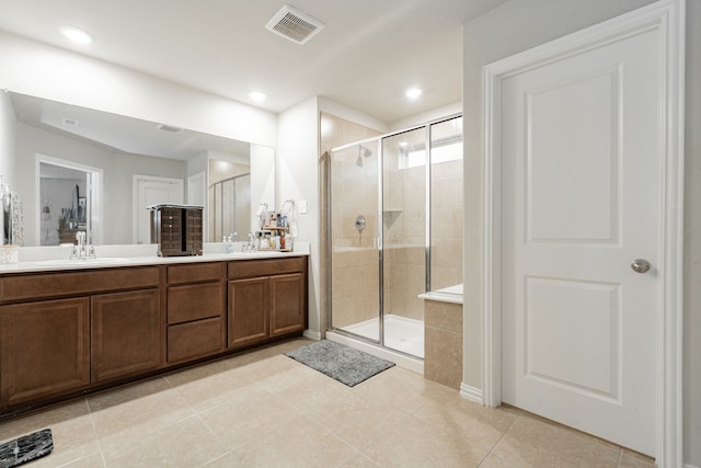 bathroom featuring walk in shower, vanity, and tile patterned floors