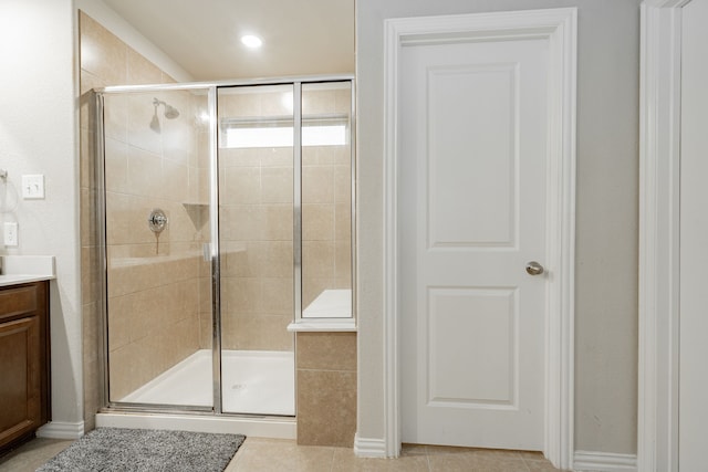 bathroom featuring tile patterned floors, vanity, and a shower with shower door