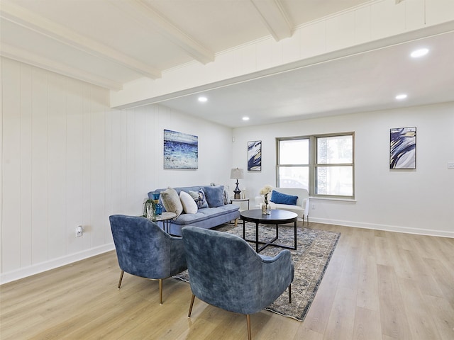 living room featuring light hardwood / wood-style flooring, wood walls, and beam ceiling