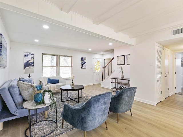 living room with beamed ceiling and light wood-type flooring