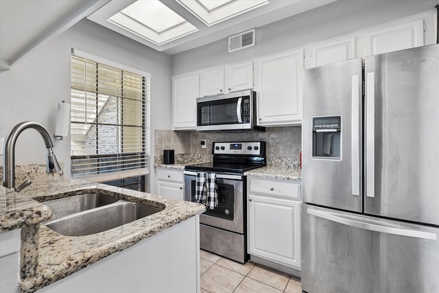 kitchen featuring appliances with stainless steel finishes, sink, and white cabinets