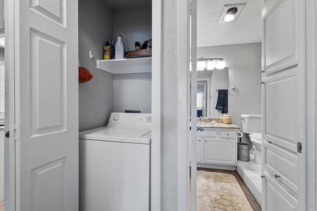 laundry room featuring light hardwood / wood-style flooring, washer / clothes dryer, and sink