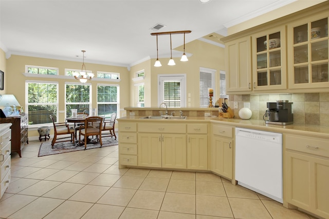 kitchen with cream cabinets, tasteful backsplash, hanging light fixtures, white dishwasher, and sink