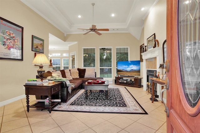 living room featuring crown molding, a raised ceiling, light tile patterned floors, and ceiling fan with notable chandelier