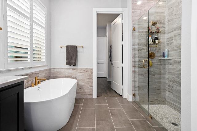 bathroom with vanity, tile patterned flooring, and plus walk in shower