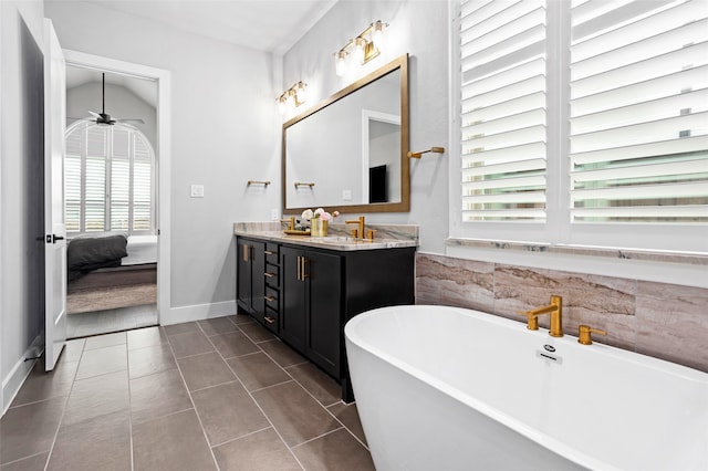 bathroom with a wealth of natural light, vanity, a tub, and ceiling fan