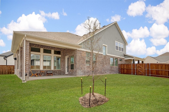 back of property with a patio and a yard