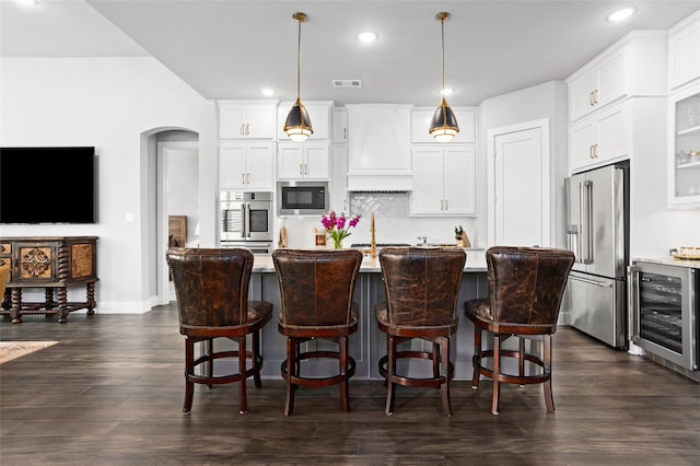 kitchen featuring white cabinetry, wine cooler, appliances with stainless steel finishes, and hanging light fixtures