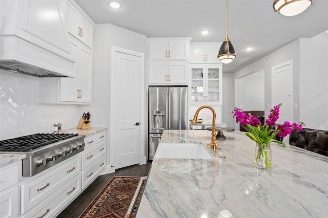 kitchen with stainless steel appliances, pendant lighting, white cabinetry, premium range hood, and dark hardwood / wood-style flooring