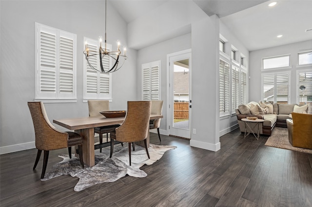 dining space featuring a wealth of natural light, lofted ceiling, dark wood-type flooring, and a notable chandelier