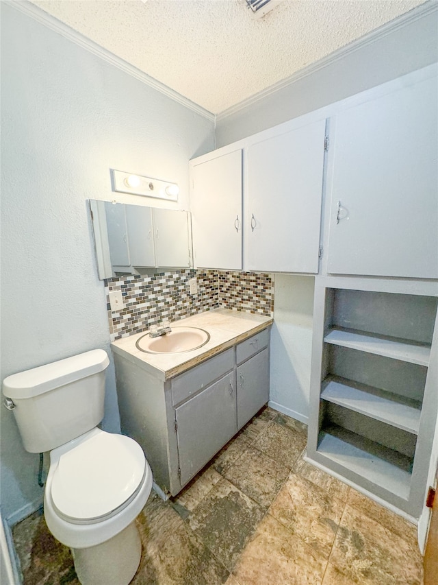 bathroom featuring tasteful backsplash, a textured ceiling, toilet, vanity, and crown molding