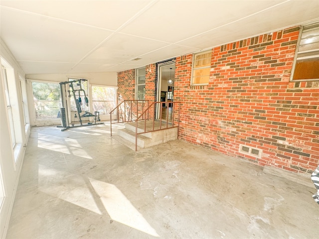 interior space featuring concrete floors and brick wall