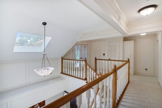 hall with light colored carpet, crown molding, and vaulted ceiling