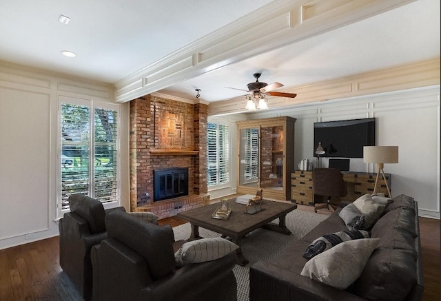 living room featuring a brick fireplace, ceiling fan, dark hardwood / wood-style flooring, and ornamental molding