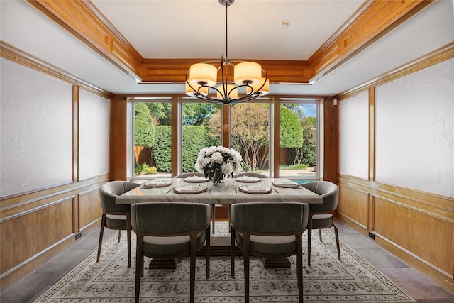 dining room featuring ornamental molding, a raised ceiling, and a notable chandelier