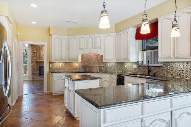 kitchen with a center island, white cabinetry, hanging light fixtures, and sink