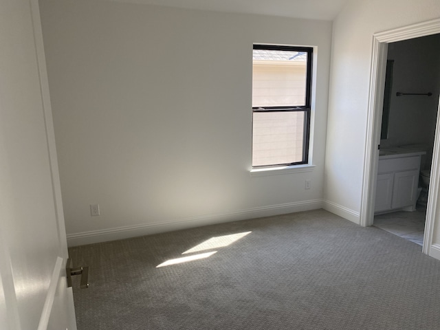 unfurnished bedroom featuring carpet and ensuite bathroom