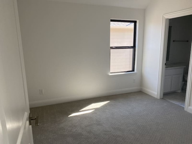 unfurnished bedroom with connected bathroom and carpet