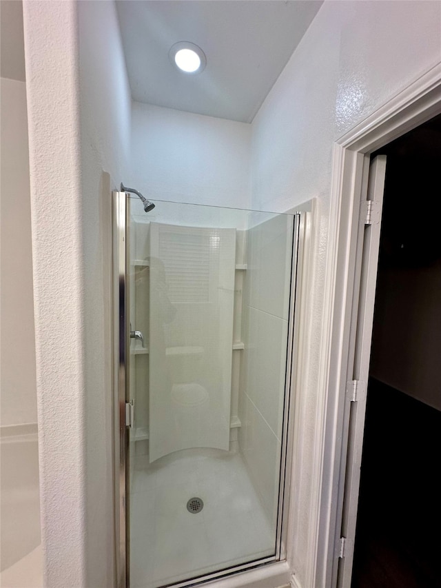 bathroom with a shower with door