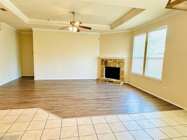 unfurnished living room with light hardwood / wood-style flooring, crown molding, and a tray ceiling