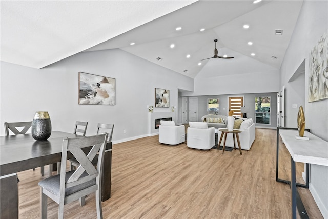 dining area with high vaulted ceiling, light wood-type flooring, and ceiling fan