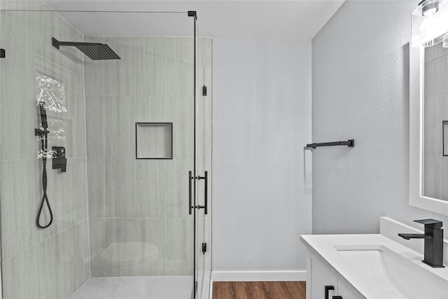 bathroom featuring vanity, hardwood / wood-style flooring, and a shower with shower door