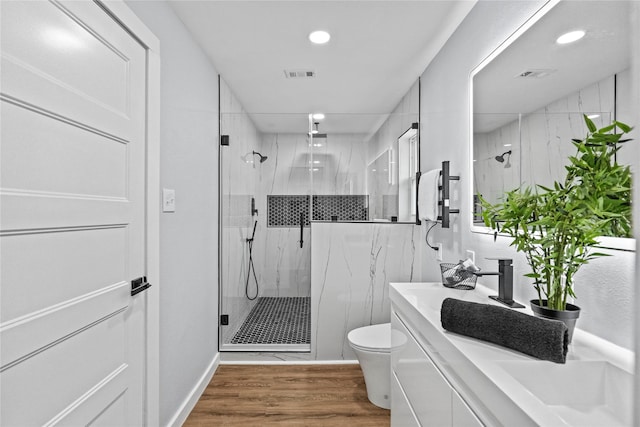 bathroom with vanity, toilet, hardwood / wood-style flooring, and a shower with shower door