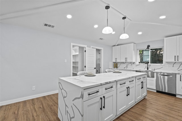 kitchen with lofted ceiling, dishwasher, wood-type flooring, a center island, and white cabinets