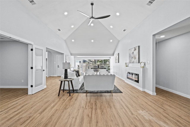 living room with light hardwood / wood-style floors, high vaulted ceiling, and ceiling fan