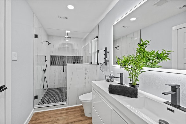 bathroom featuring toilet, an enclosed shower, hardwood / wood-style floors, and vanity