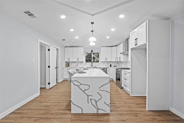 kitchen featuring white cabinetry, appliances with stainless steel finishes, a center island, and decorative light fixtures