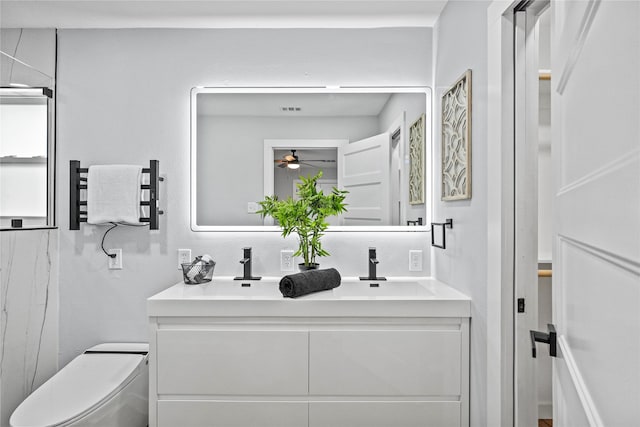 bathroom with toilet, radiator heating unit, vanity, and ceiling fan