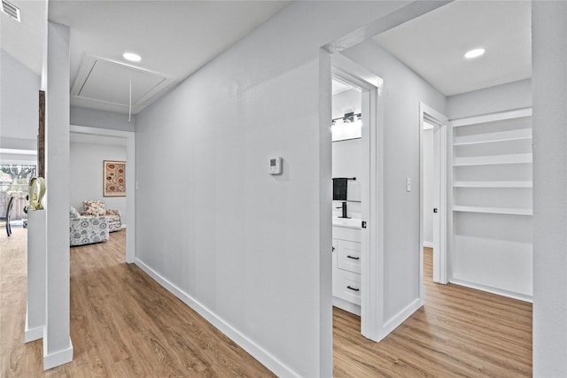 hallway with light hardwood / wood-style floors