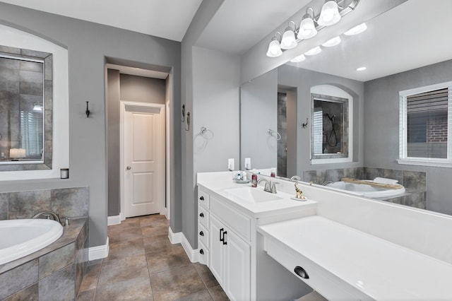 bathroom with vanity, tile patterned flooring, and a relaxing tiled tub