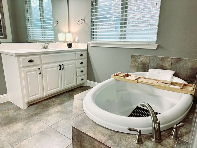 bathroom with tiled bath, vanity, and tile patterned floors