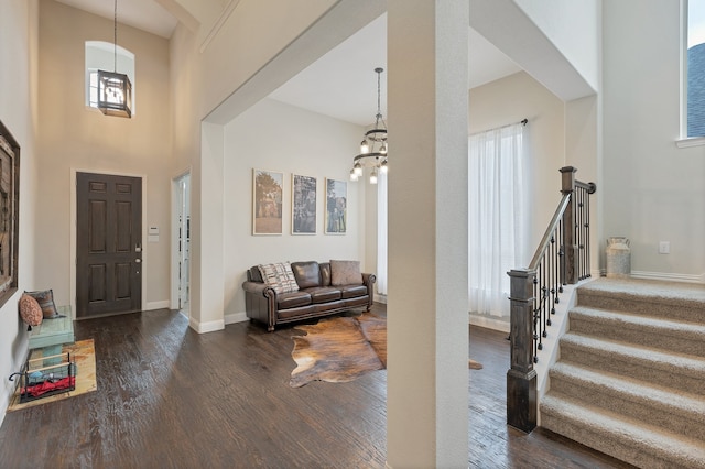 foyer entrance with dark wood-type flooring, a high ceiling, and a healthy amount of sunlight